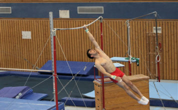 Yumito Nishiura im Einturnen der Landesmeisterschaften bei der einarmigen Riesenfelge am Reck.