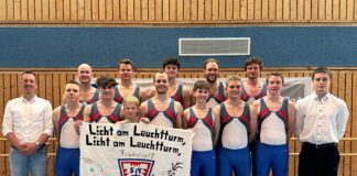 TSV-Turnteam mit Banner beim Wettkampf, Gruppenfoto in der Sporthalle
