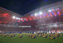 Turner zeigen Akrobatik bei der Stadiongala des Turnfests 2025 im bunt beleuchteten Stadion in Leipzig.