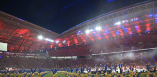 Turner zeigen Akrobatik bei der Stadiongala des Turnfests 2025 im bunt beleuchteten Stadion in Leipzig.