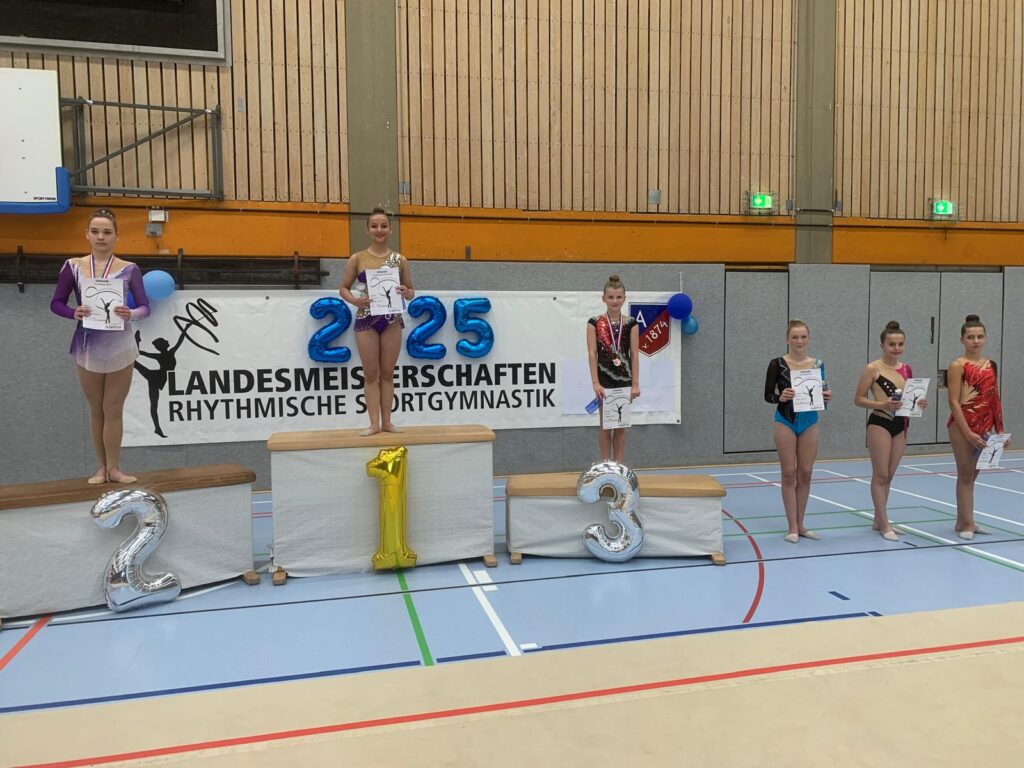 Siegerehrung bei einem Turnwettbewerb mit Podestplätzen und Teilnehmerinnen (AK 13-15), die Urkunden halten.