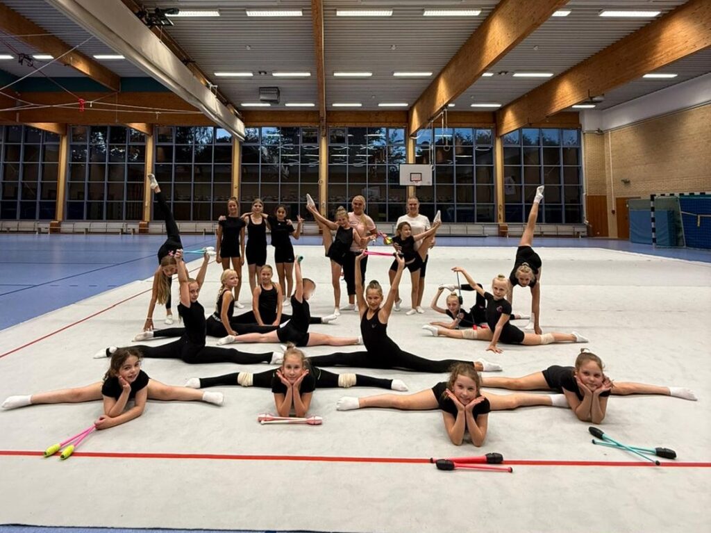 Gruppe von Gymnastinnen beim posieren in einer Turnhalle