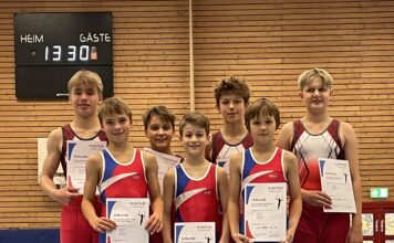 Turner auf einem Kasten in der Sporthalle