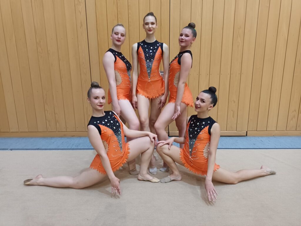 Turnerinnen posen für Foto in Sporthalle