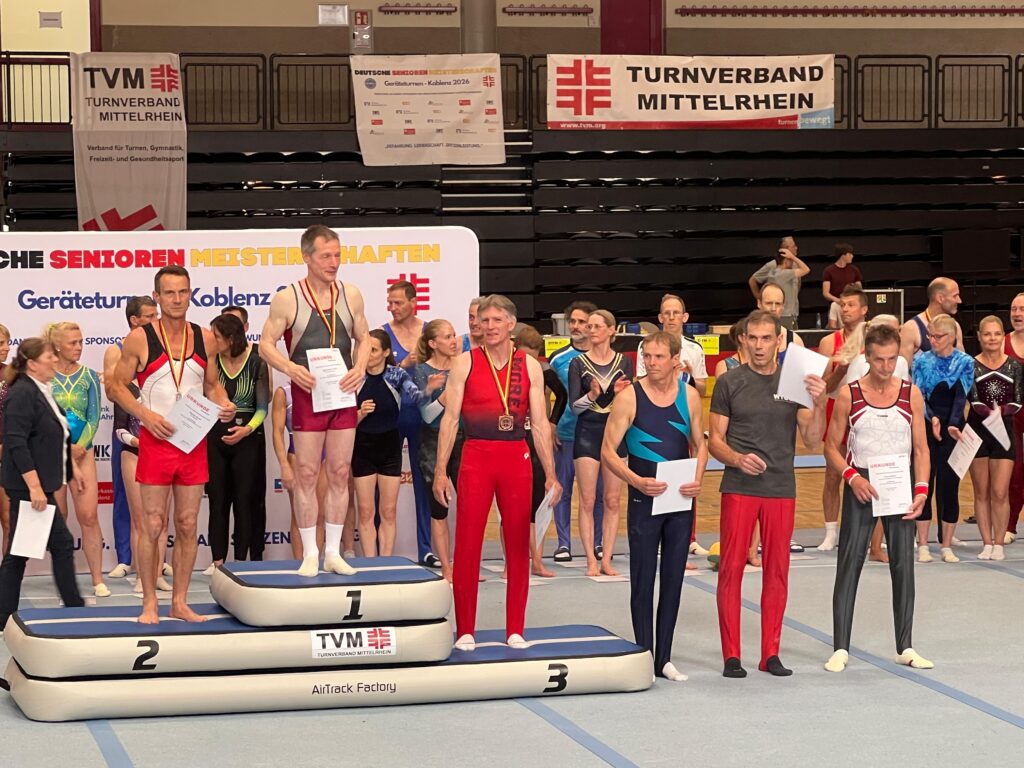 Turner in Turnhalle auf Podium