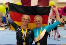 Seniorenturnerinnen in Turnhalle halten Deutschlandfahne