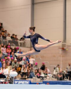 Turnerin im Sprung in einer Sporthalle