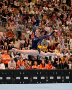 Turnerin im Sprung in einer Sporthalle