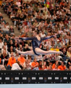 Turnerin im Sprung in einer Sporthalle